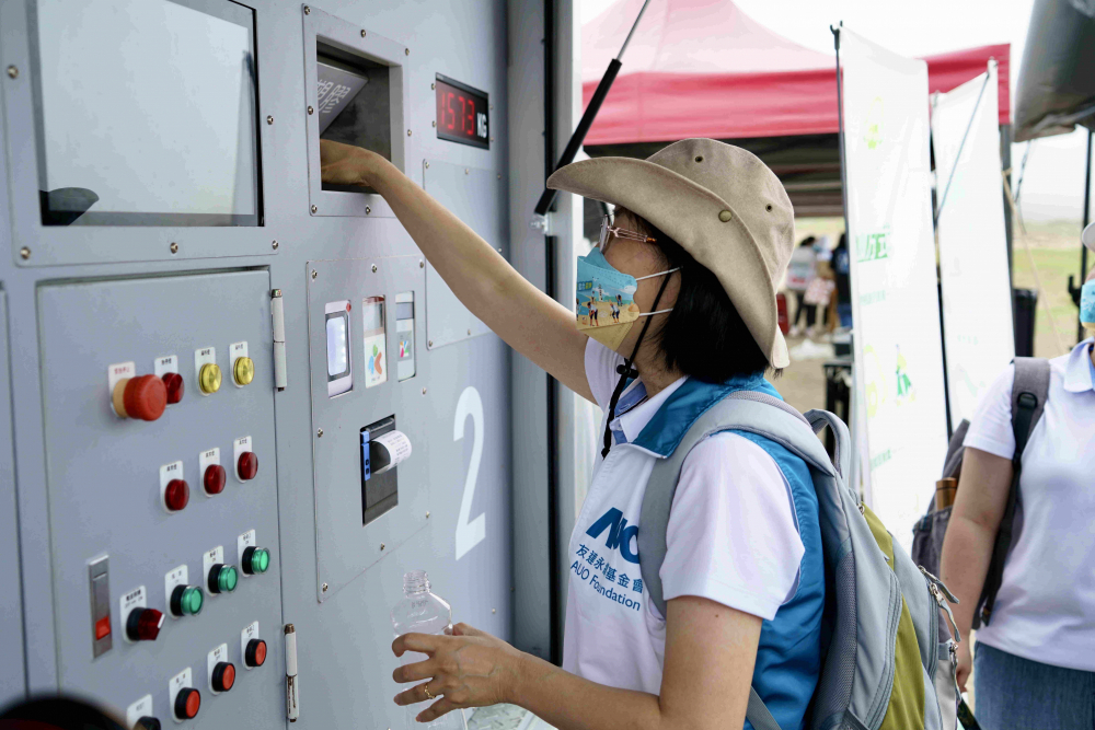 志工們將拾起的寶特瓶投入「好歸塑專車」，讓廢棄塑料空瓶可以直接粉碎、縮小體積，未來將可再製成購物袋、寶特衣、悠遊卡等生活用品